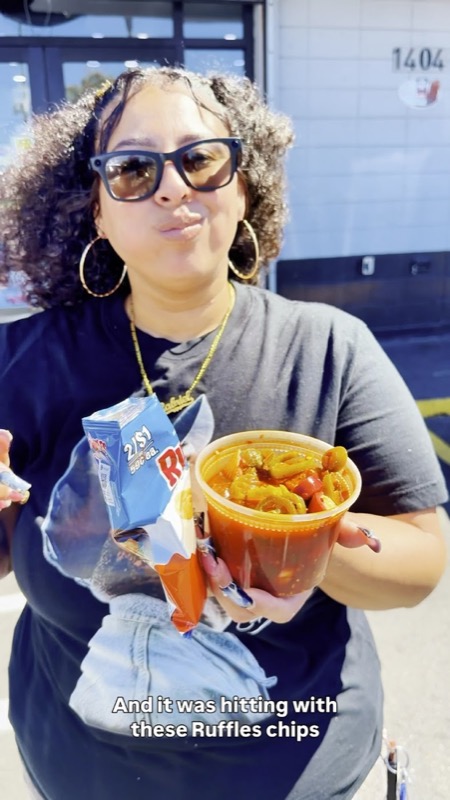 Customer with a spicy bowl outside The Burg Food Mart
